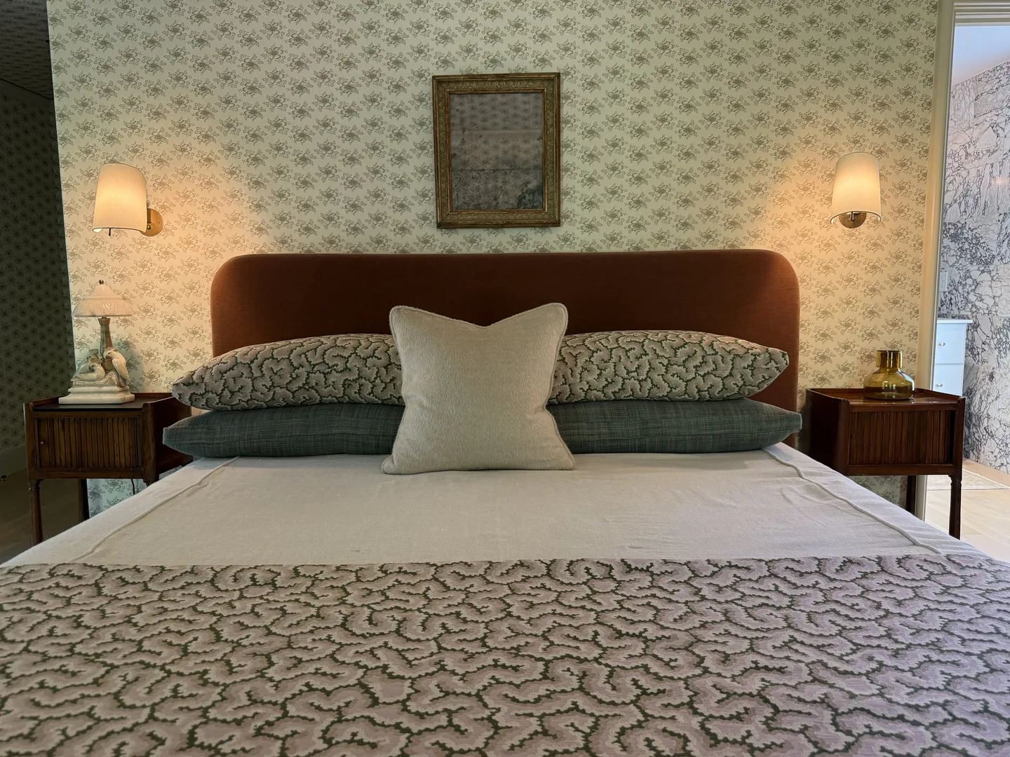 Primary bedroom bed styling with ambient lighting